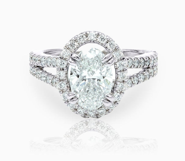 Lab-grown oval diamond halo ring in 14K white gold with sparkling center and side stones.